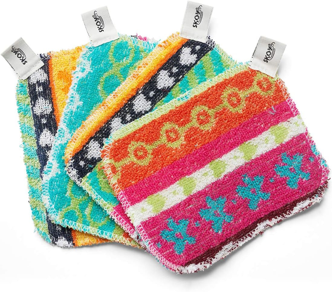 Set of four reusable non-scratch dish scrubbers in assorted colors on a kitchen counter.
