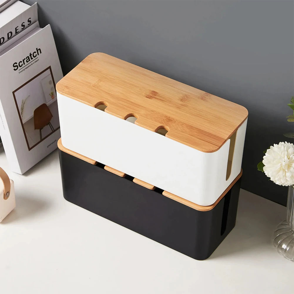 Wooden-style cable management box concealing cords and a power strip under a desk.