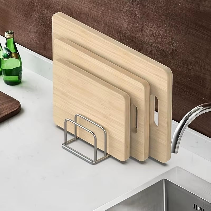Stainless steel countertop rack organizing pot lids and cutting boards side by side.