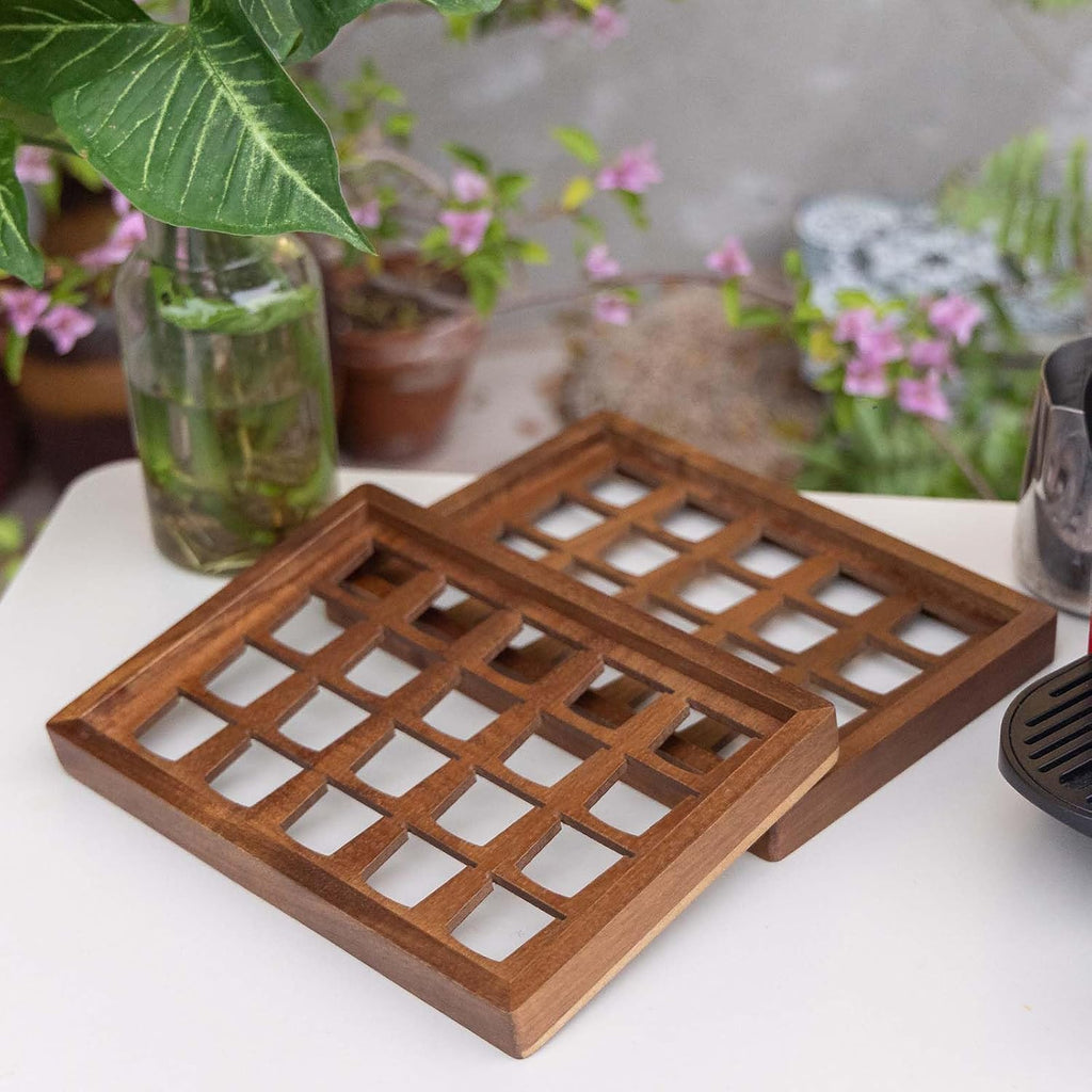 Two acacia wood coffee pod holder trays displayed on a kitchen countertop coffee bar.