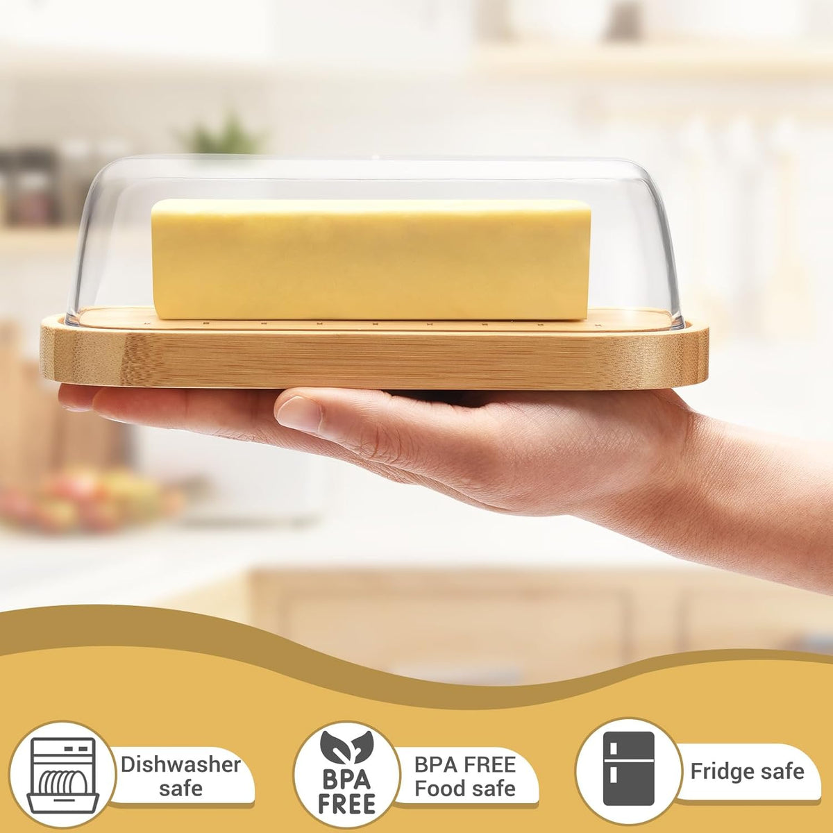 Bamboo butter dish with lid holding a stick of butter on a kitchen counter.