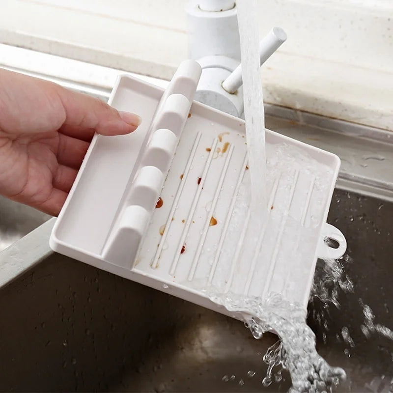 Non-slip kitchen utensil holder resting a spoon and spatula on a countertop.