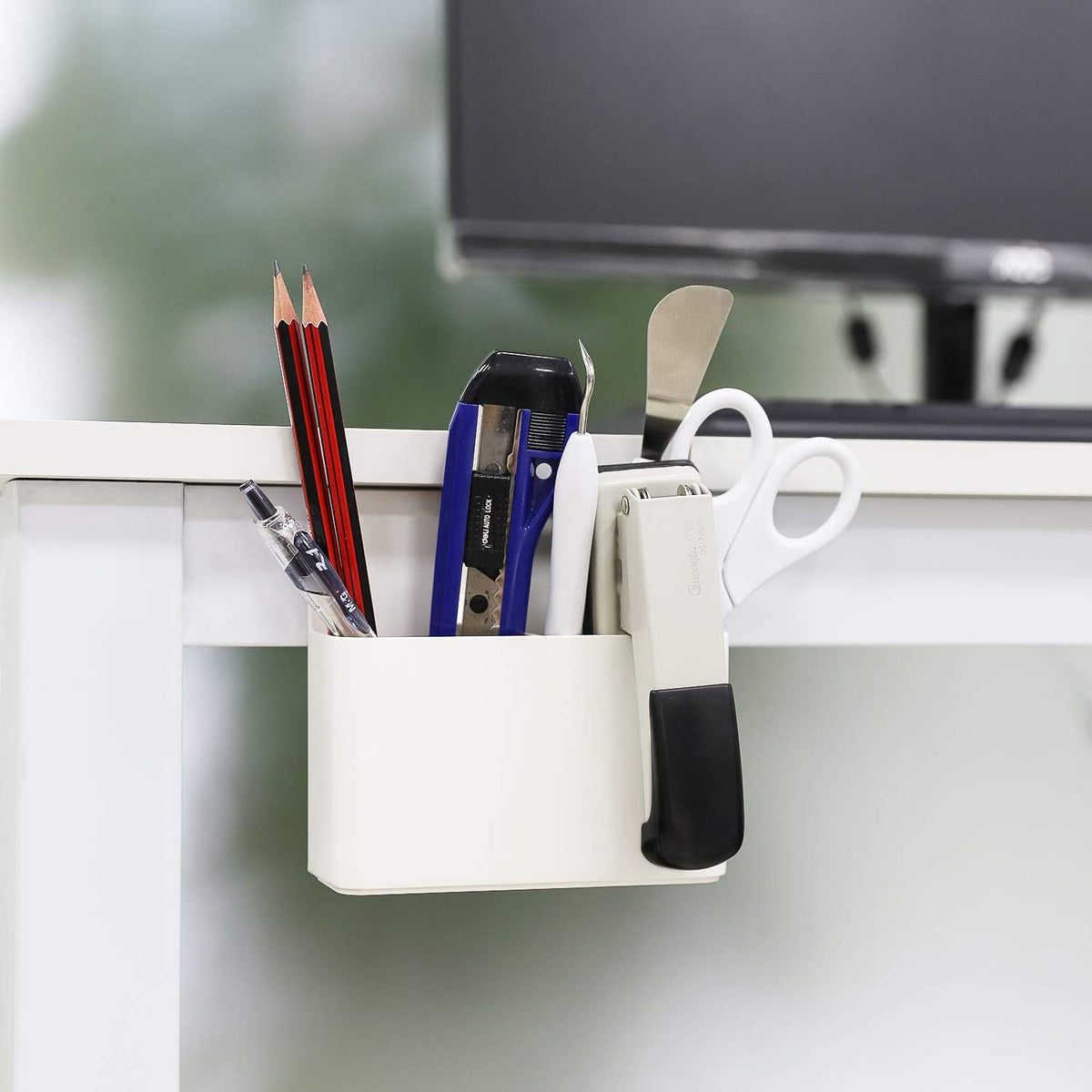 White magnetic marker holder attached to a whiteboard holding dry erase markers.