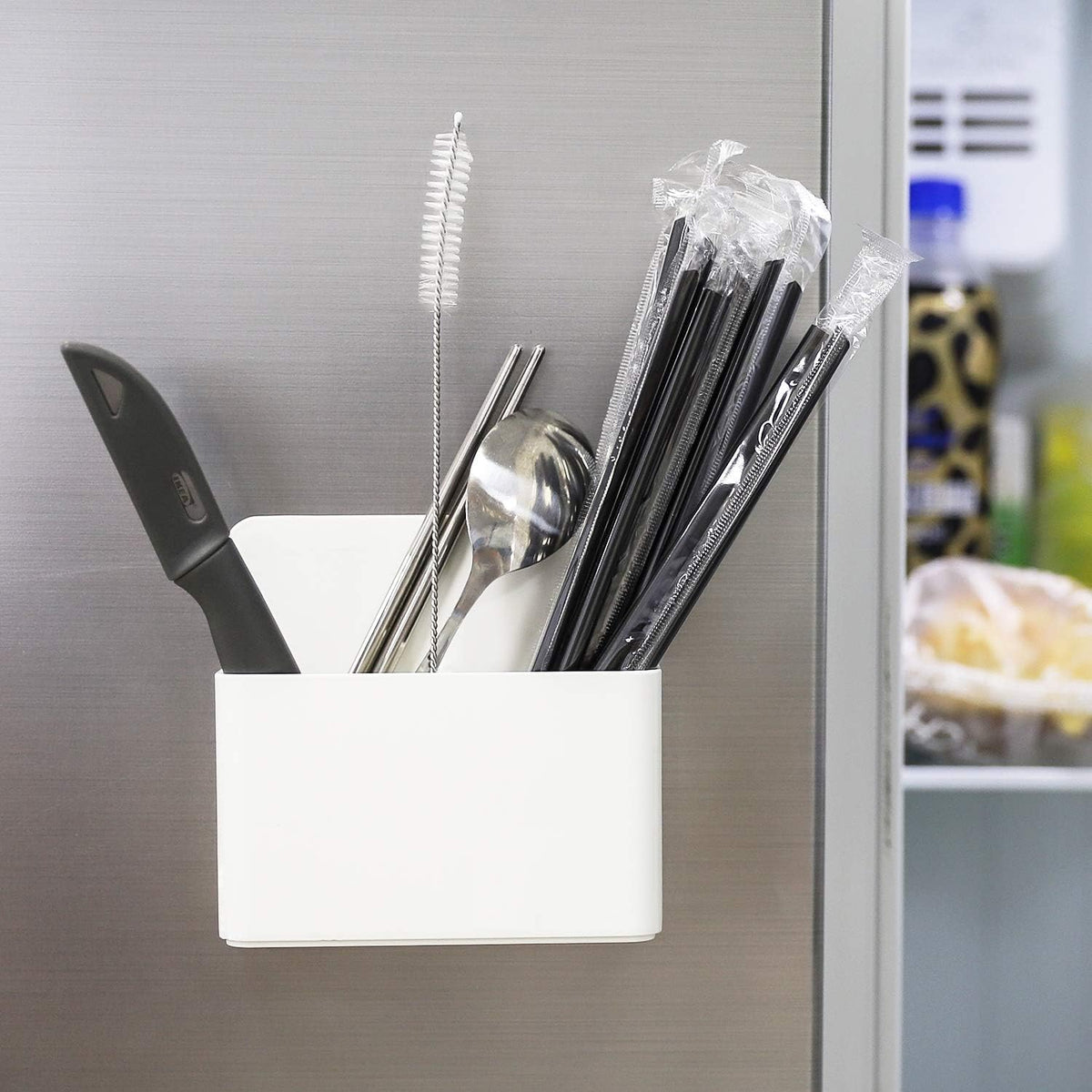 White magnetic marker holder attached to a whiteboard holding dry erase markers.
