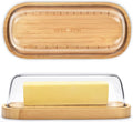 Bamboo butter dish with lid holding a stick of butter on a kitchen counter.