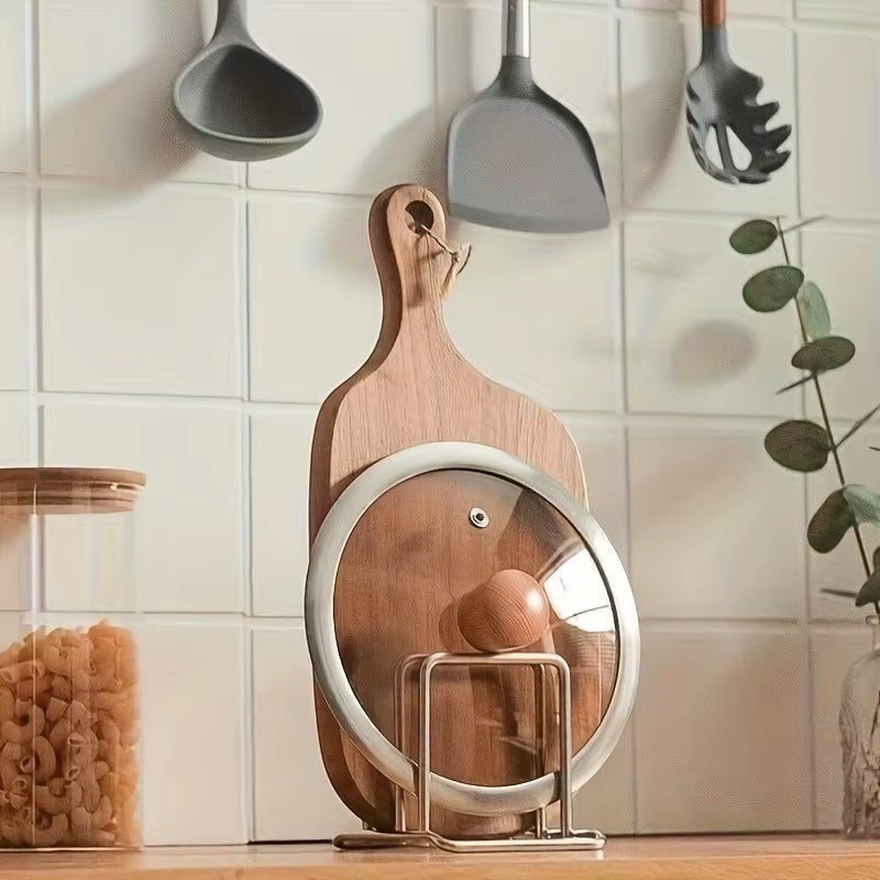 Stainless steel countertop rack organizing pot lids and cutting boards side by side.