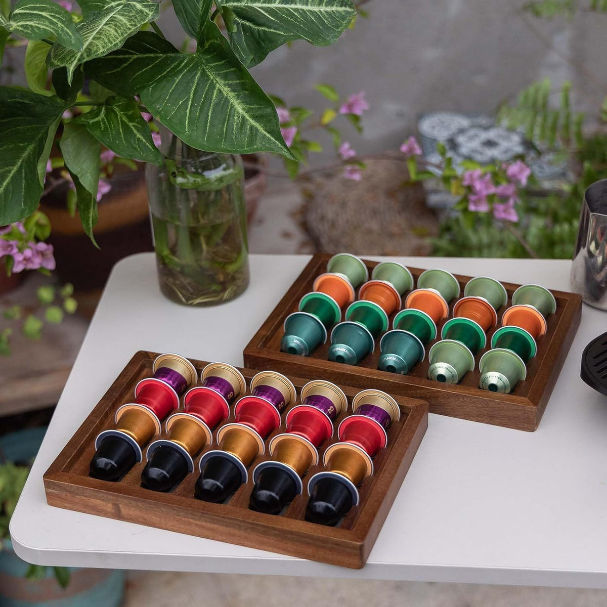 Two acacia wood coffee pod holder trays displayed on a kitchen countertop coffee bar.