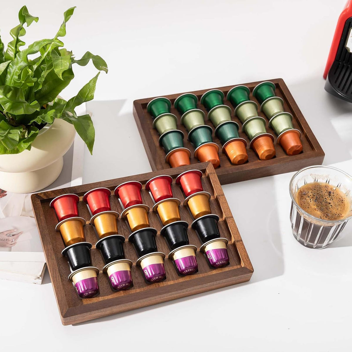 Two acacia wood coffee pod holder trays displayed on a kitchen countertop coffee bar.