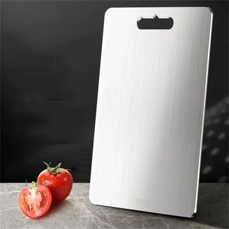 Stainless steel antibacterial cutting board on a kitchen counter with sliced vegetables.